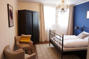 a bedroom with a bed and a chair and a chandelier at Stylish New City Appartement in Graz