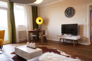 a living room with a couch and a tv at Stylish New City Appartement in Graz +9 photos