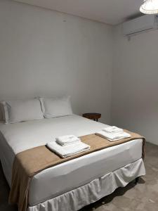 a white bed with two towels on top of it at Marinho Suítes Milagres in São Miguel dos Milagres +26 photos
