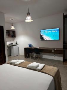 a bedroom with a bed and a table and a tv at Marinho Suítes Milagres in São Miguel dos Milagres +26 photos