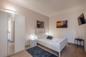 Un dormitorio blanco con una cama y un espejo. en Frisi 3 City Center Suite - B Home, en Milán