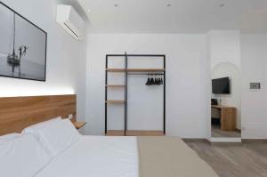 a white bedroom with a bed and a closet at Sabbia Tropea Apartments and Rooms in Tropea