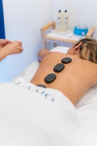 a woman laying on a bed with pills on her back at Miramare Sea Resort & Spa in Ischia