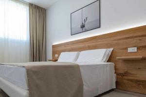 a bedroom with a white bed with a picture on the wall at Sabbia Tropea Apartments and Rooms in Tropea