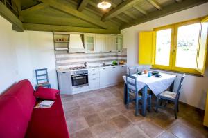 cocina con sofá rojo y mesa en una habitación en Chalet Luna di Miele - a due passi dalla Spiaggia, en Bolsena