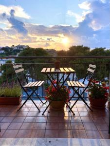 d'une table et de chaises sur un balcon avec vue sur le coucher du soleil. dans l'établissement Charming places Casa A, just a few steps from the sea, à Portoferraio