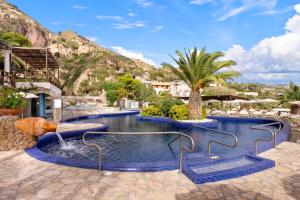 a pool at a resort with a palm tree at Miramare Sea Resort & Spa in Ischia