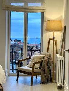 a room with a chair and a large window at Las Terrazas de Candás in Candás