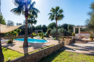 a villa with a swimming pool and palm trees at Finca Linda in Campos