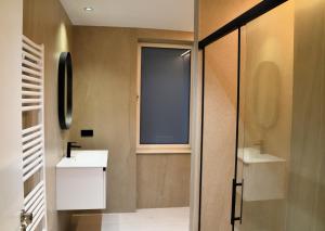 a bathroom with a sink and a glass shower door at Las Terrazas de Candás in Candás +33 photos
