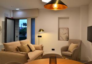 a living room with a couch and chairs and a table at Las Terrazas de Candás in Candás