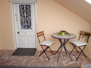 a room with a table and two chairs and a door at Le cocon d'Aurélie in Vélizy-Villacoublay +1 photo