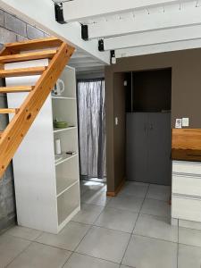 una sala de estar con escalera y una habitación con TV en Duplex Rio Uruguay 161, en Monte Hermoso