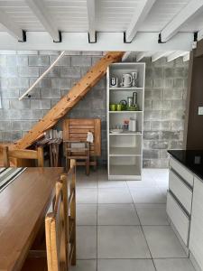 una cocina con escalera, mesa y sillas en Duplex Rio Uruguay 161, en Monte Hermoso