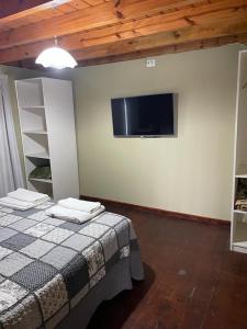 Un dormitorio con una cama y un televisor de pantalla plana. en Duplex Rio Uruguay 161, en Monte Hermoso