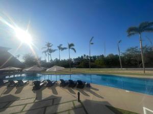 a swimming pool with lounge chairs and palm trees at Departamento en Nuevo Vallarta in Nuevo Vallarta  +6 photos