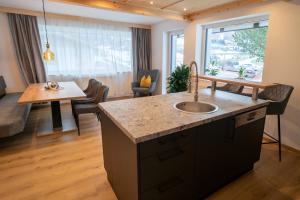 a kitchen with a sink and a living room at Apartement Waldfrieden in Pfons