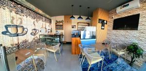 a restaurant with tables and chairs and a refrigerator at Grand Orchid Hotel Apartment in Duqm