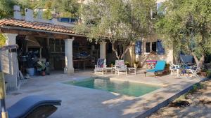 a house with a swimming pool with chairs and a patio at L'Eterlou Saint Blaise, bel appartement neuf mansardé in Saint-Blaise