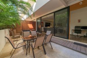 a dining room with a glass table and chairs at Spacious Condo 200m from Beach & 5th Ave in Playa del Carmen