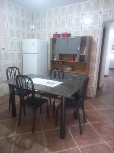 a kitchen with a table and chairs and a refrigerator at Pousada Malu III in Bragança Paulista
