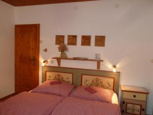 um quarto com uma cama com um edredão vermelho em Bauernhof im Wiesengrund em Maria Luggau