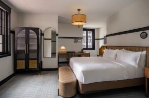 ein Schlafzimmer mit einem großen weißen Bett und einem Schreibtisch in der Unterkunft Visitation Hotel Fredrick, a Tribute Portfolio Hotel in Frederick + 101 Fotos