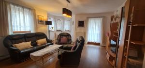 sala de estar con sofá de cuero y mesa en Camping Gasthof Zirknitzer, en Großkirchheim