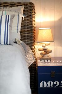 a bedroom with a bed and a lamp on a nightstand at Villa Land-Zee, à 10mn de Royan in Saujon