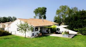 a white house with a frisbee in the yard at Villa Land-Zee, à 10mn de Royan in Saujon