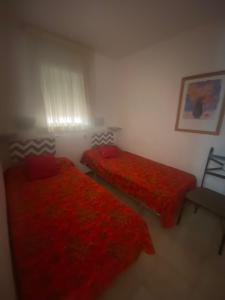 2 camas en una habitación con sábanas rojas en Gran Reserva 24, en Empuriabrava