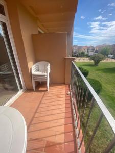 un balcón con una silla blanca en el porche en Gran Reserva 24, en Empuriabrava