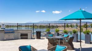 a patio with a table and chairs and an umbrella at Sparks 1BR Water Views · Spring & Rooftop Patio in Sparks