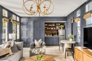 una sala de estar con paredes azules y una lámpara de araña. en Serene Cottage with Beautiful Garden and Heated Pool, en Charleston