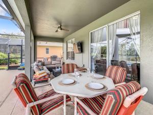 ein Esszimmer mit einem weißen Tisch und Stühlen in der Unterkunft 7BR Villa in Emerald Island w/ Resort Perks in Kissimmee