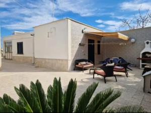 een patio met stoelen en tafels en een gebouw bij Villa Teresa in Giovinazzo