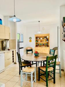a kitchen with a dining room table and chairs at Secluded Villa with Private Pool Almyrida in Almirida +23 photos