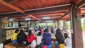 a group of people sitting at a table in a restaurant at Nhà sàn cộng đồng in Thanh Sơn