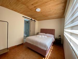 a bedroom with a bed and a bathroom with a window at Casa Hernandez in La Calera