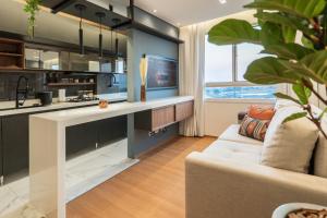 a living room with a couch and a kitchen at Apartamento alto padrão, Arena MRV, 2 quartos, garagem in Belo Horizonte