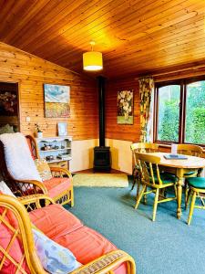 Allerthorpeにある'Mallard' Secluded Fishermans Lodgeの暖炉とテーブルと椅子のあるリビングルーム