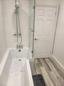 a white bathroom with a tub and a shower at Seaside 3 Bedroom Home in Ramsgate