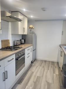 a kitchen with white cabinets and stainless steel appliances at Seaside 3 Bedroom Home in Ramsgate