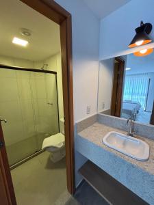 a bathroom with a sink and a toilet and a mirror at Coralli Pousada in Porto De Galinhas +38 photos