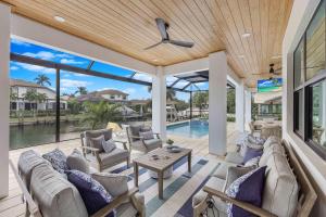 a patio with a couch and chairs and a pool at Exquisite waterfront Home featuring a pool and hot tub in Marco Island
