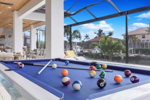 a pool table with balls on it in a house at Exquisite waterfront Home featuring a pool and hot tub in Marco Island