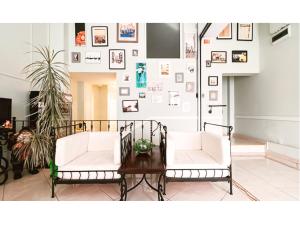 a living room with two white chairs and a table at Vila Roma in Deva