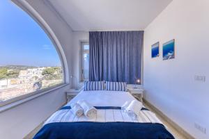 Un dormitorio con una cama con una ventana grande. en Villa Blu la Panoramica, en Castro di Lecce
