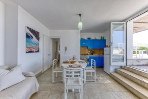 Una cocina y una sala de estar con mesa y sillas. en Villa Blu la Panoramica, en Castro di Lecce