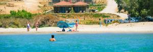 a group of people in the water at a beach at Amari Stone Apartments in Moudhros